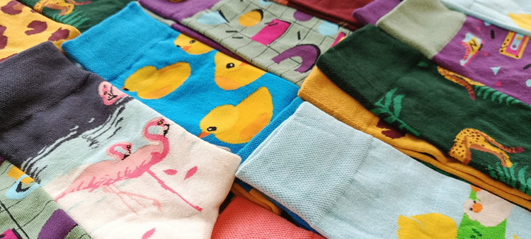 Photo d’un assortiment de chaussettes fantaisie dépareillées aux motifs variés : canards, lapins, fleurs, motifs abstraits et couleurs vives, pour une collection originale et joyeuse signée Chollala.