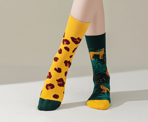 Chaussettes fantaisie dépareillées avec motifs léopard et imprimé jungle tropicale, une paire originale au style animalier et coloré.