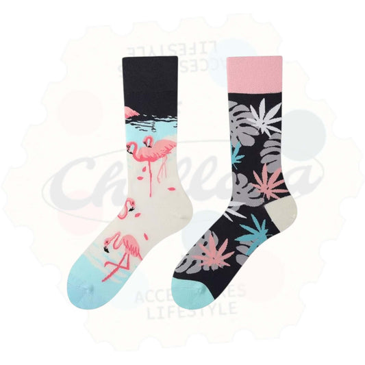 Chaussettes fantaisie dépareillées : une chaussette avec des flamants roses sur fond pastel, l’autre à motif de feuilles tropicales roses, bleues et grises sur fond noir.